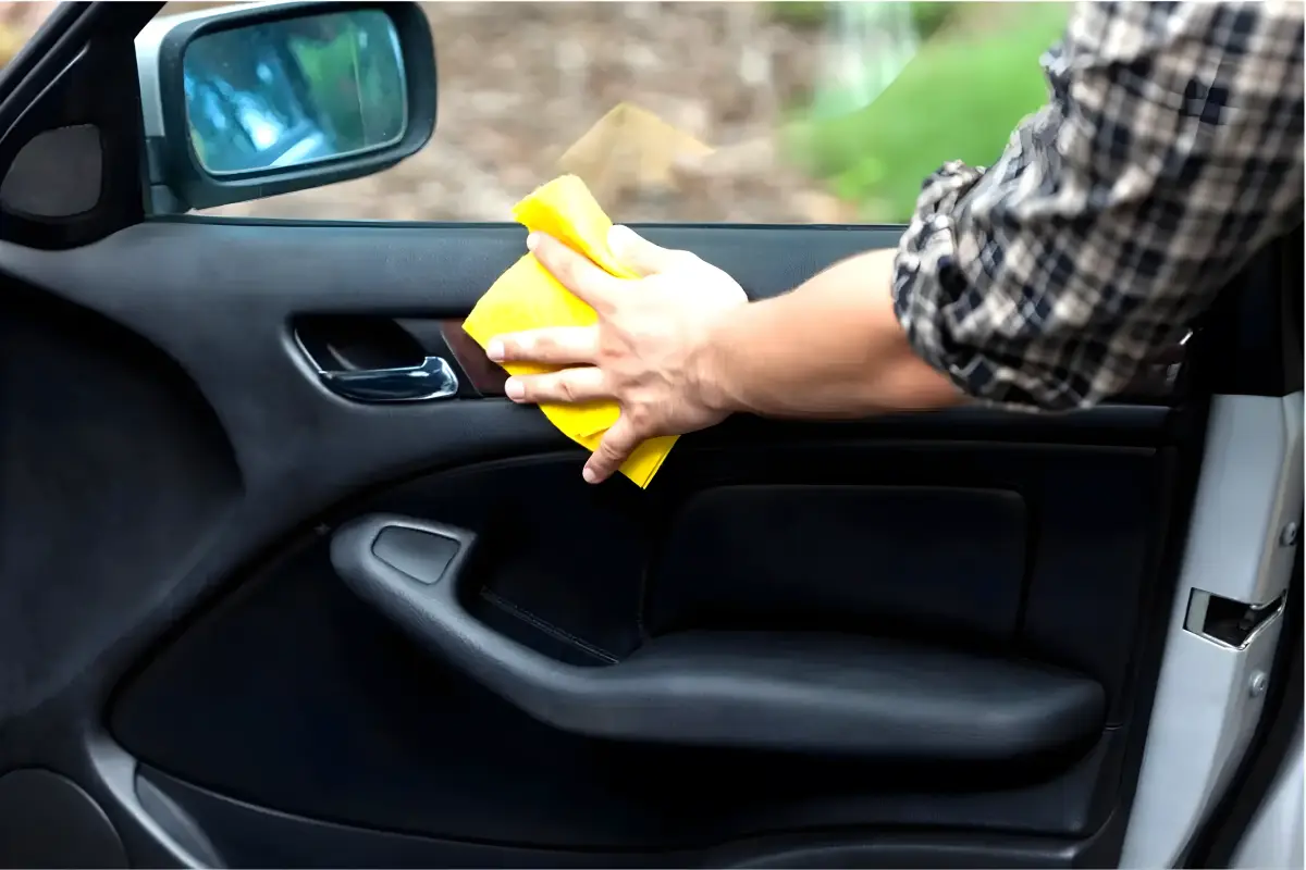 Hand polishing a car door pad with a microfibre cloth